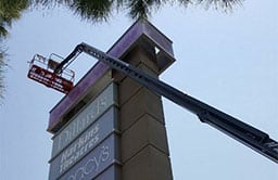 Commercial painting services on a shopping center pylon