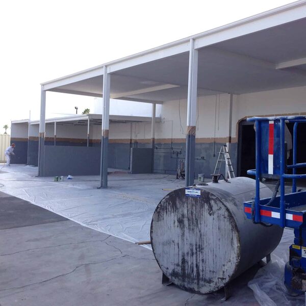 Outdoor facility undergoing painting and epoxy floor preparation